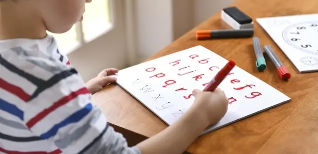 dziecko pisze literki